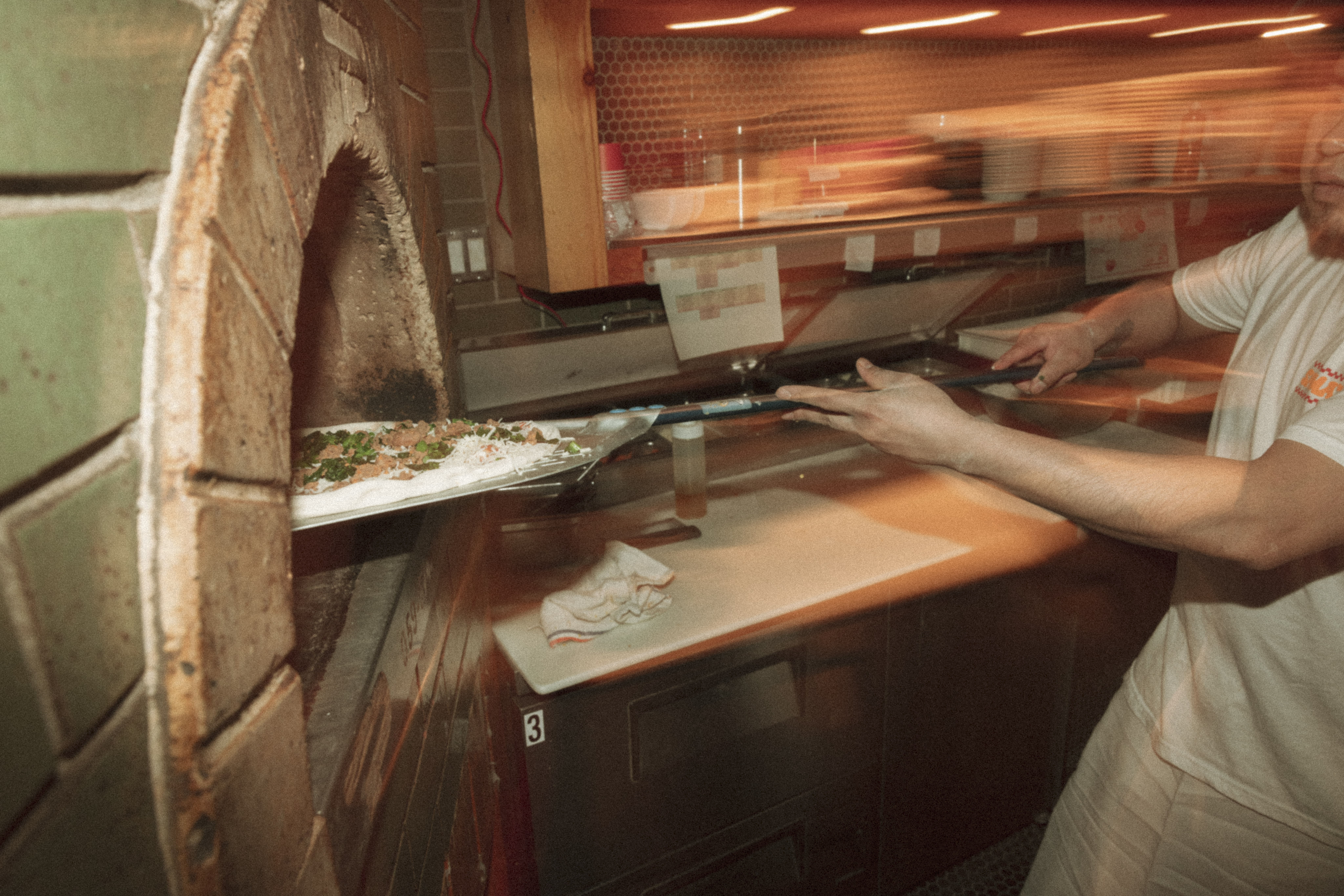 a person holding a pizza in a oven