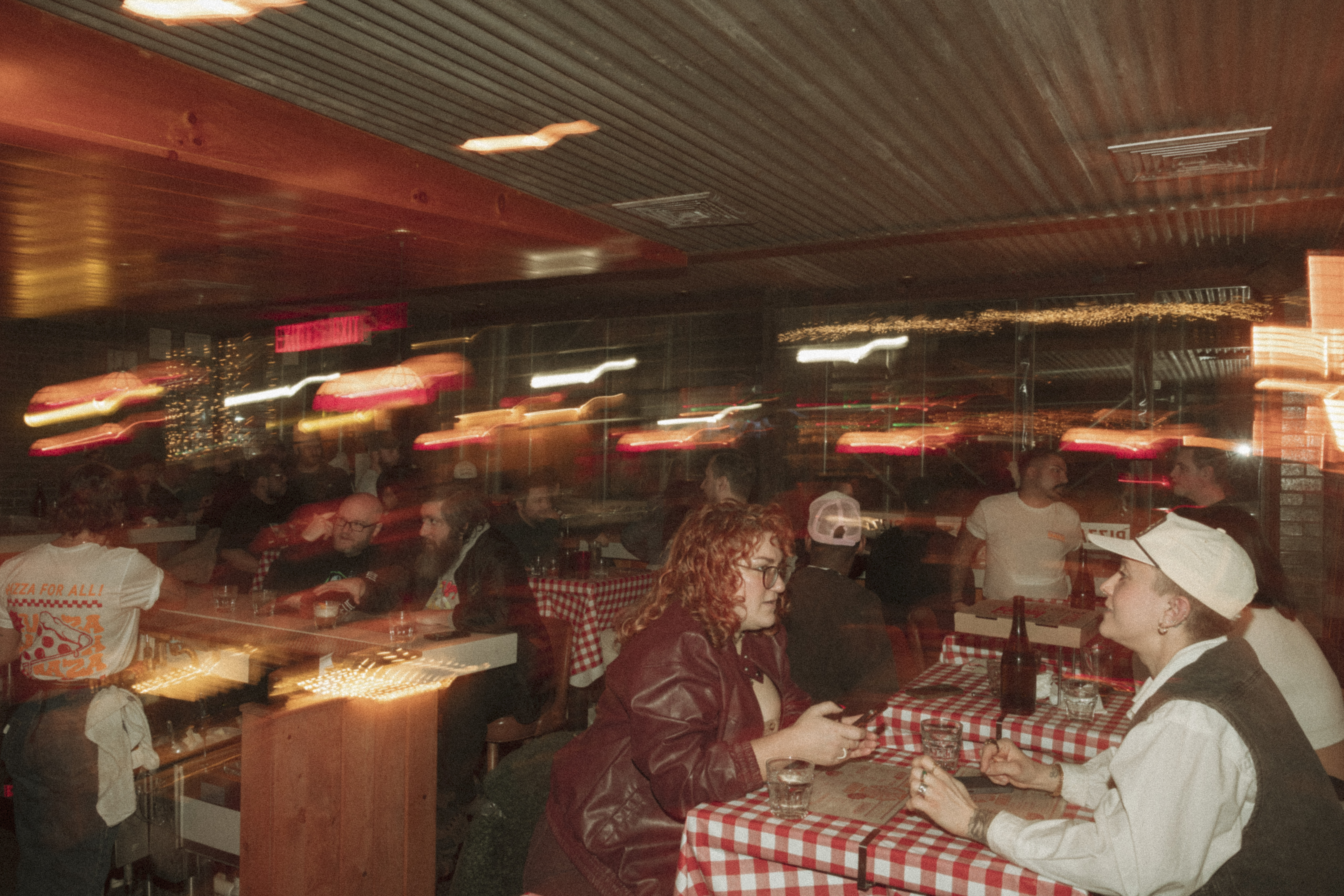 a group of people sitting at tables in a restaurant