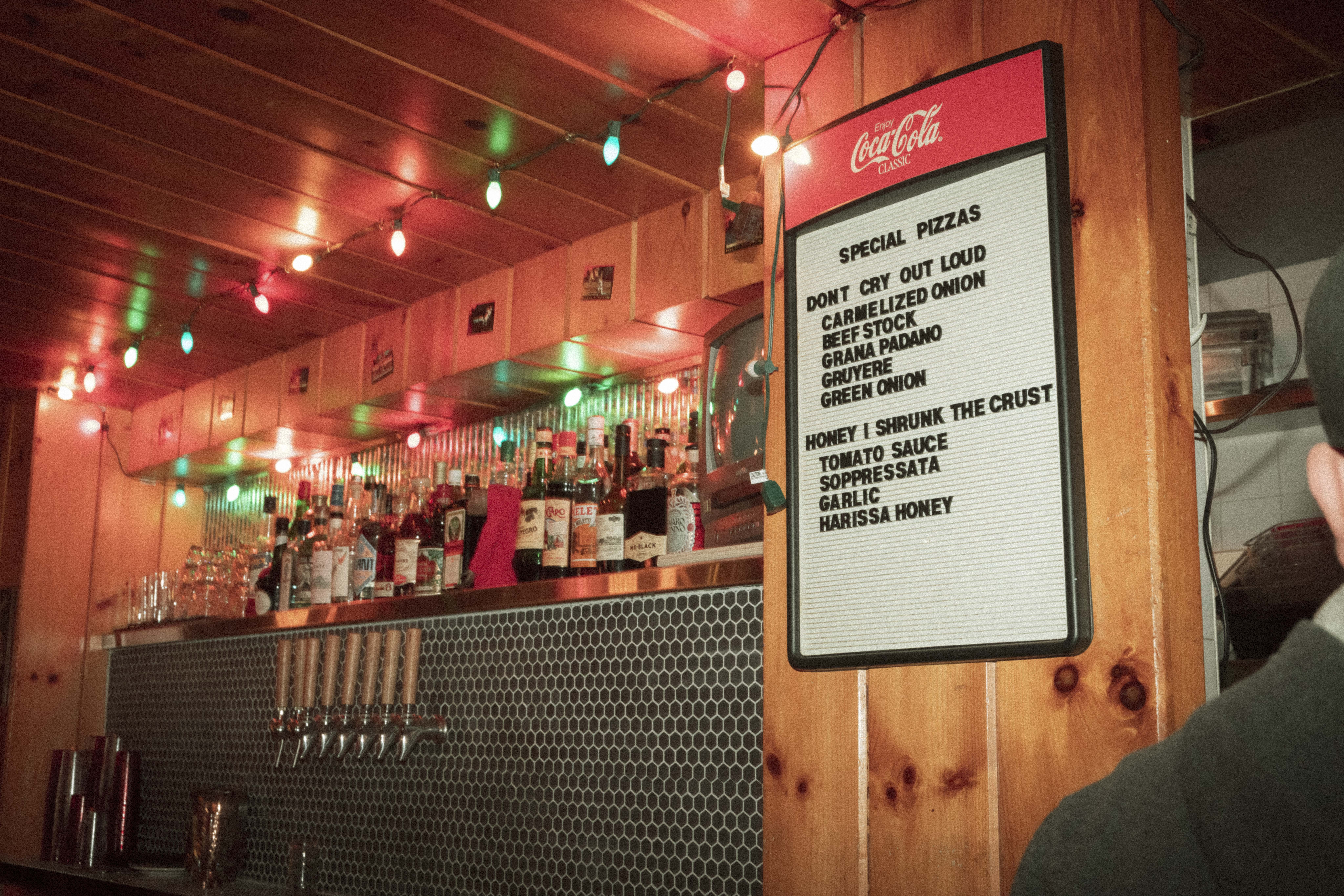 a sign on a wall with bottles of alcohol on the wall