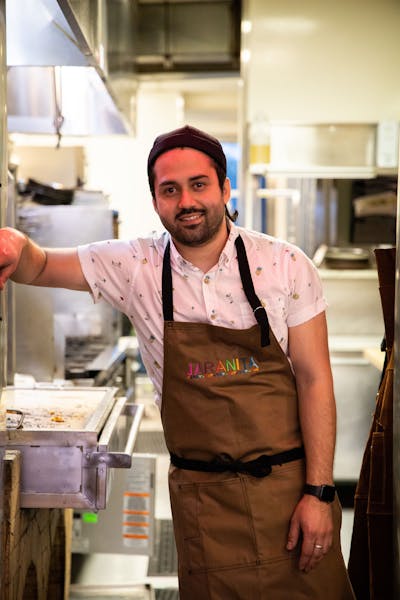 a man standing in a kitchen preparing food
