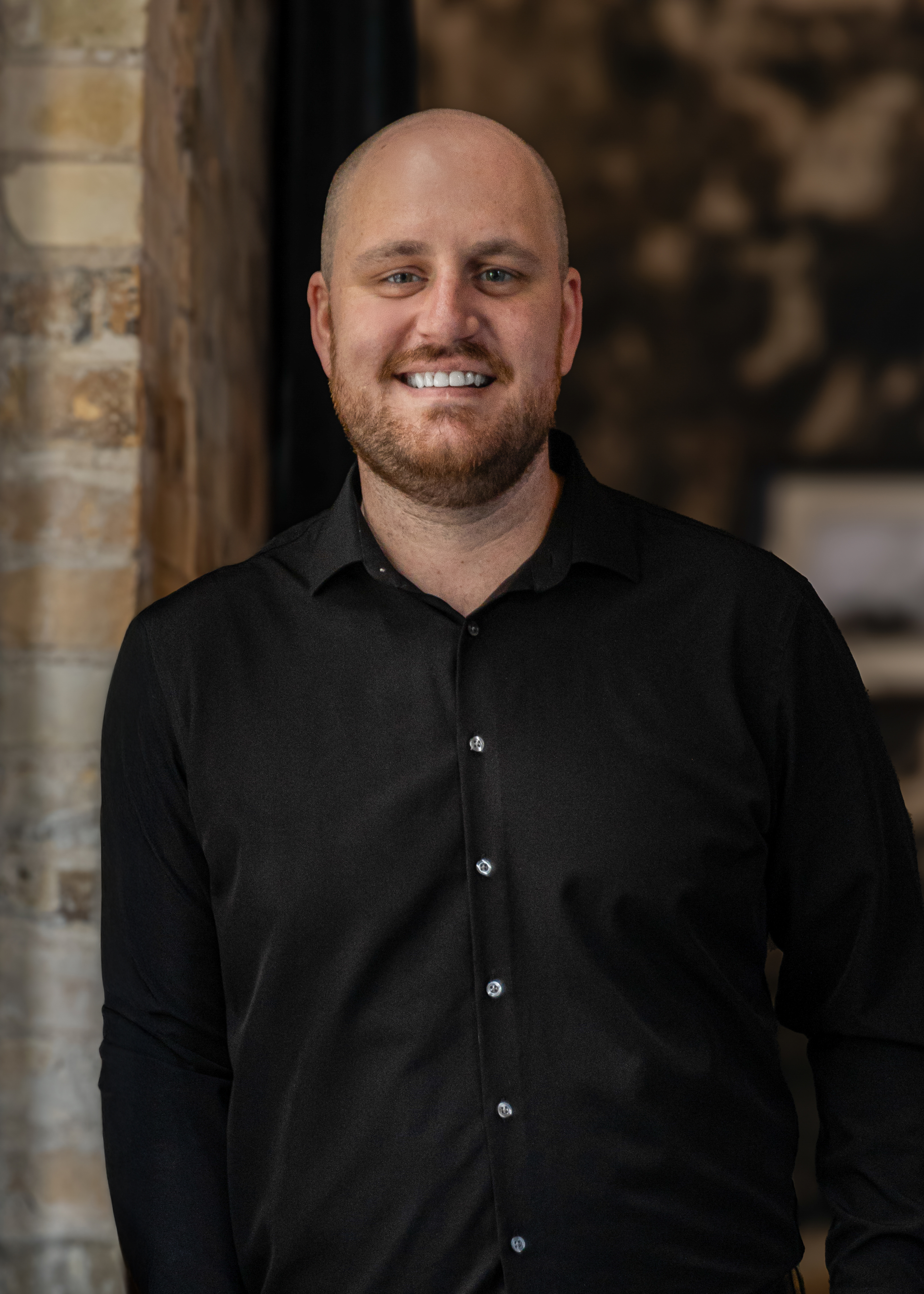 a man wearing glasses and smiling at the camera