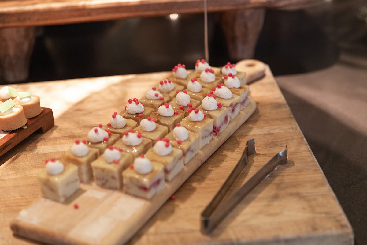 a wooden cutting board with a cake on a table