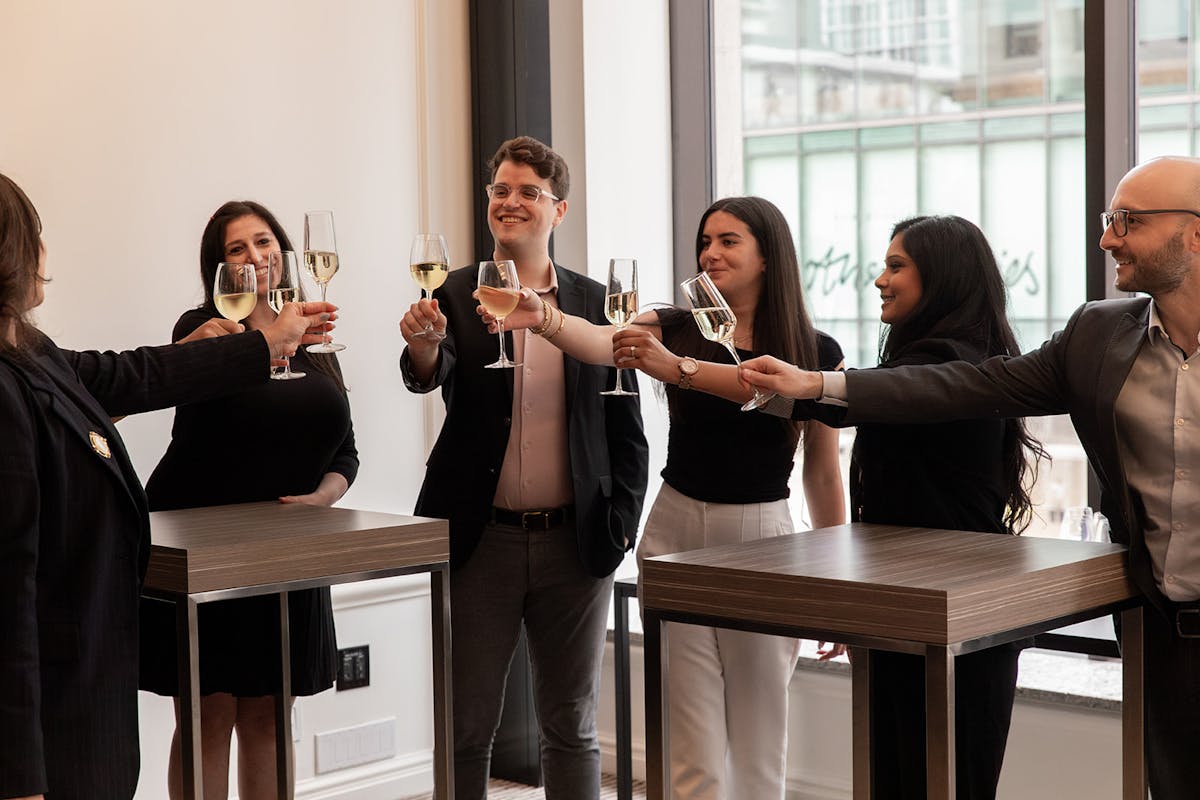 a group of people are drinking from a wine glass