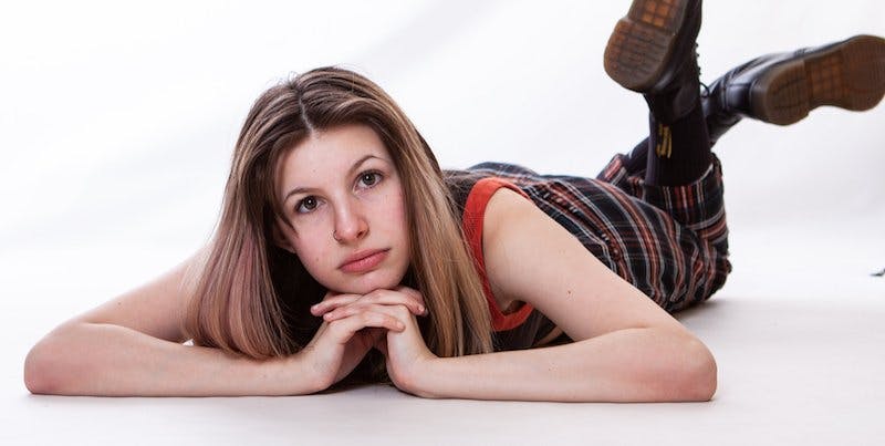 a woman lying down and looking at the camera