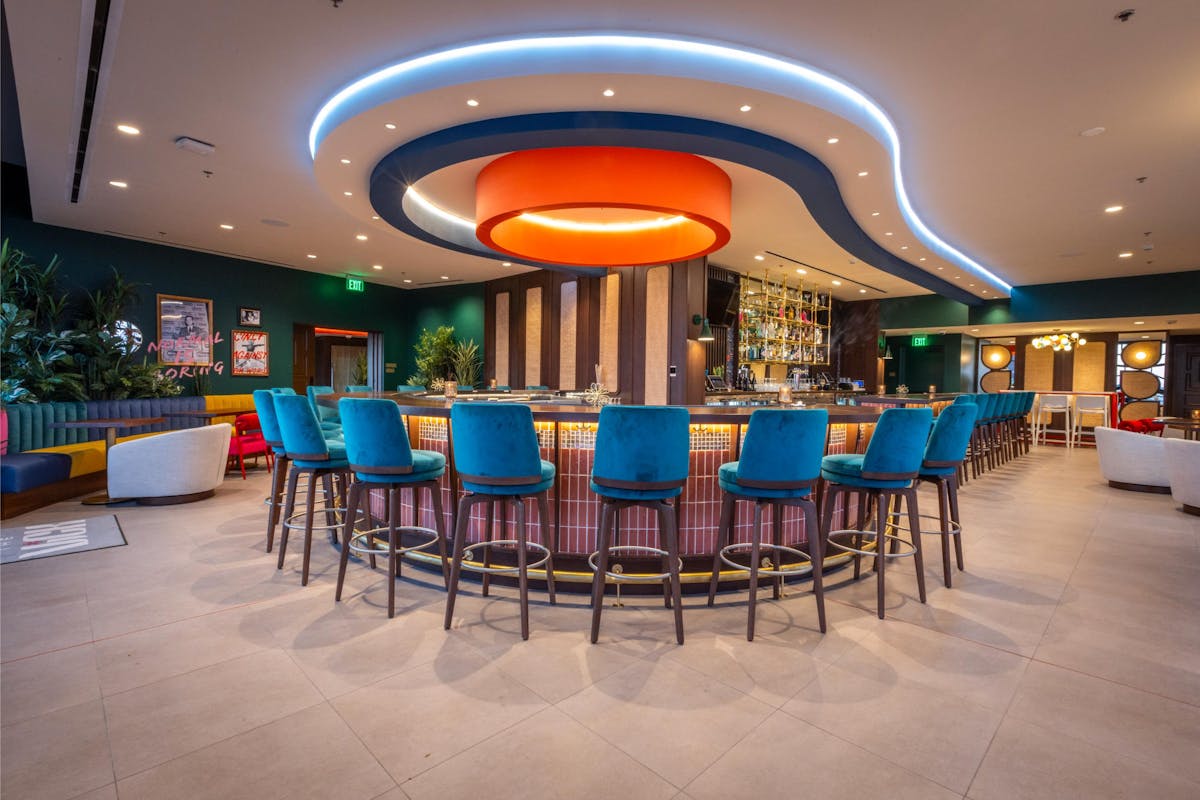 a group of people sitting at a table with a blue umbrella