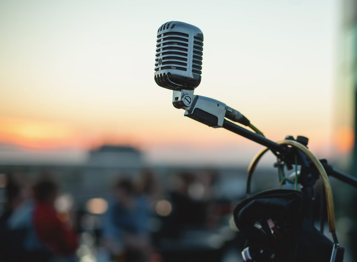 a close up of a microphone with a beautiful city sunset in the background; taken from a rooftop