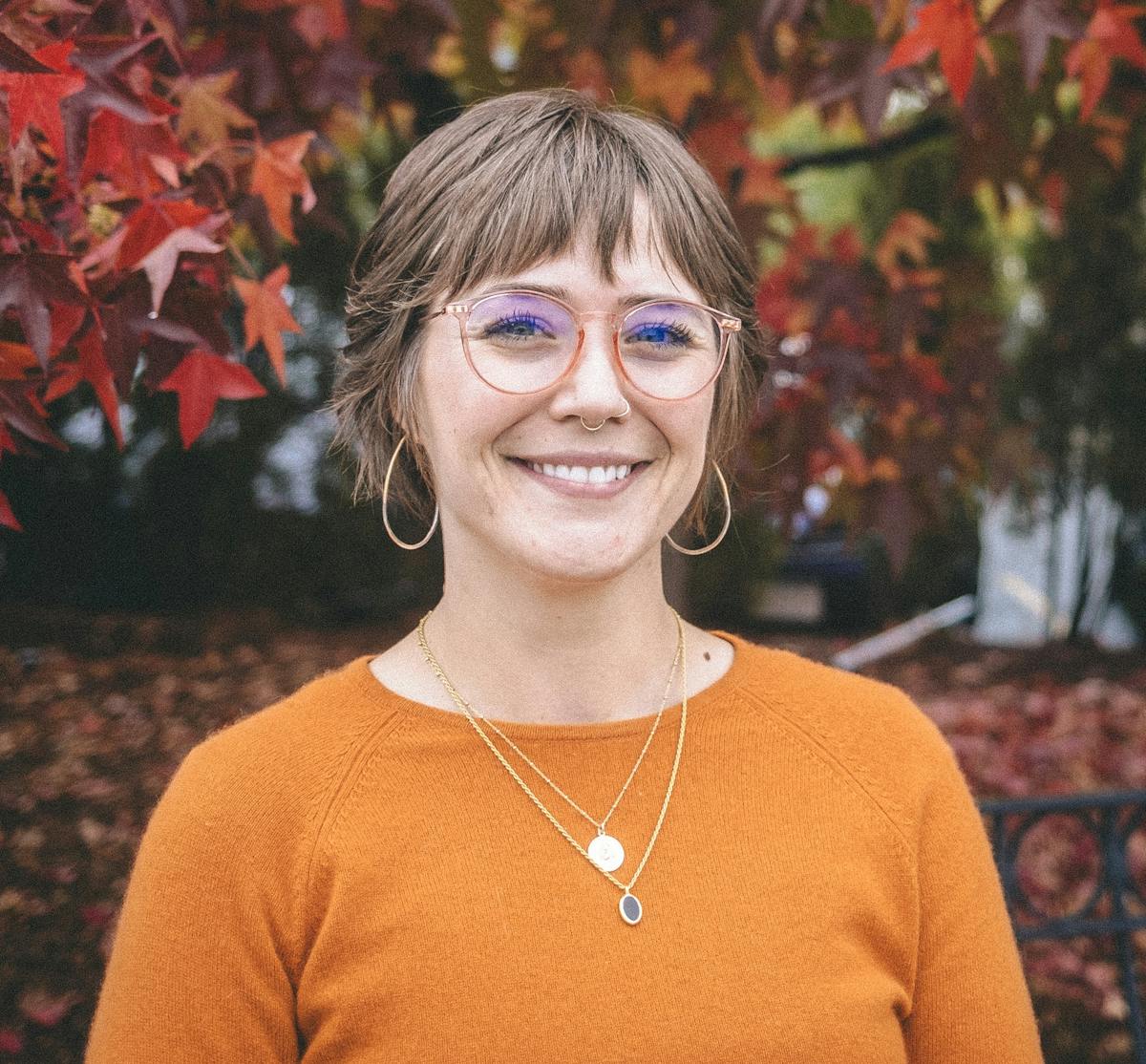 a person wearing glasses and smiling at the camera