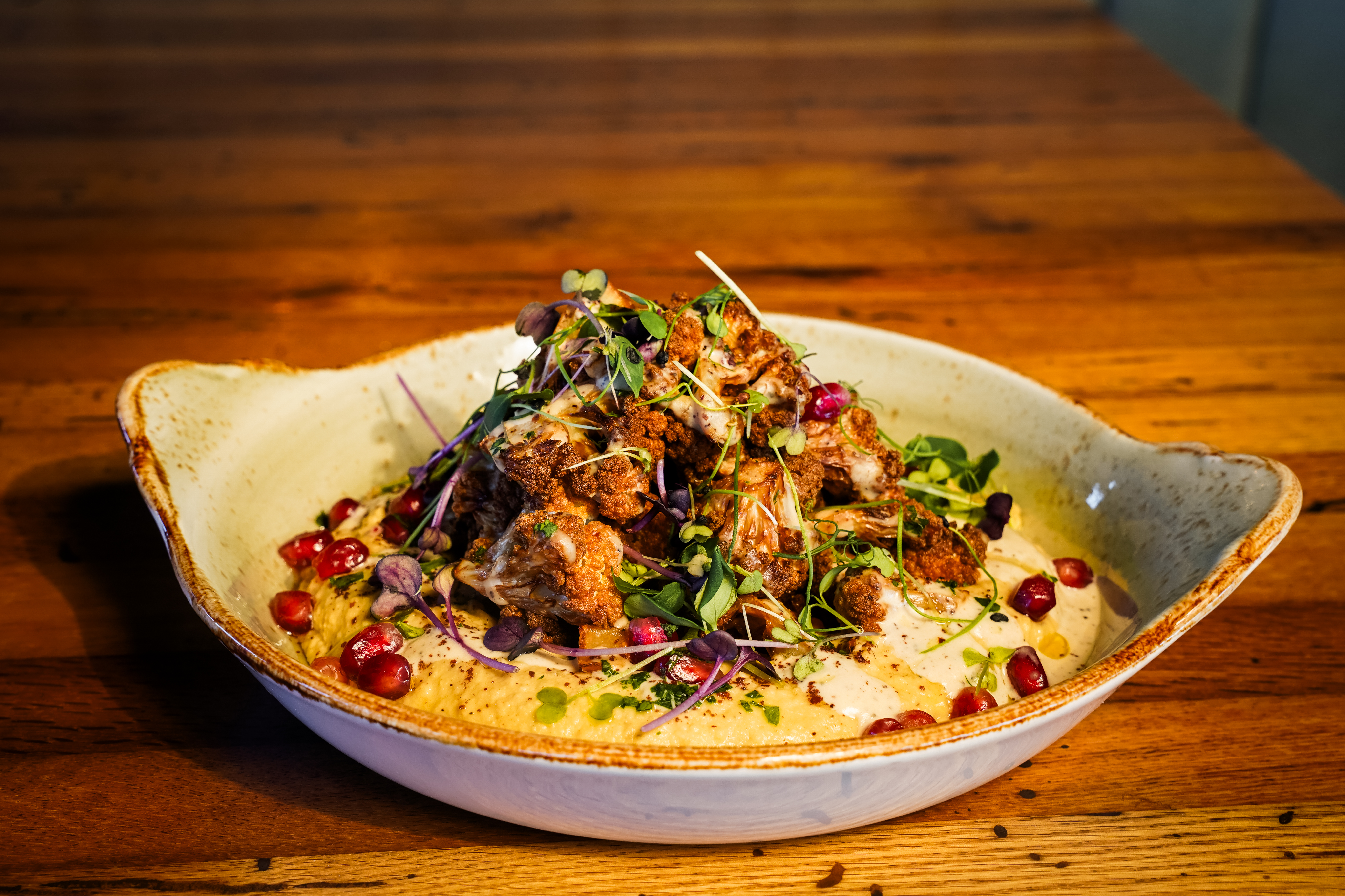a plate of food with a slice of pizza on a wooden table