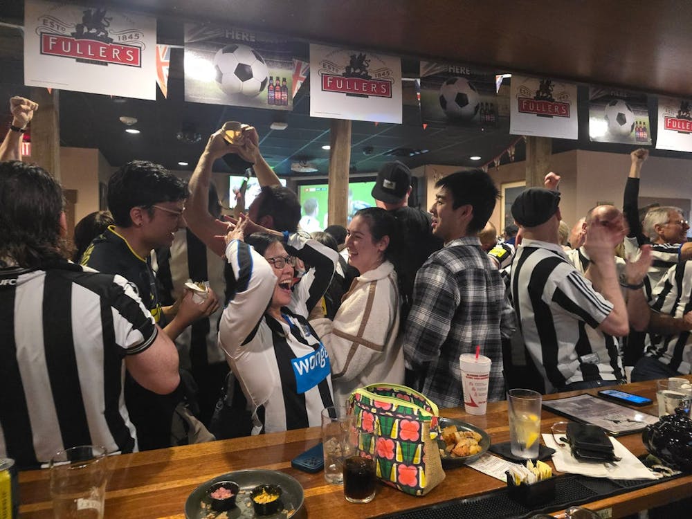 a group of people standing around a table