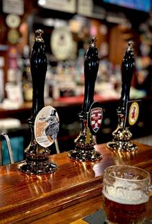 A row of beer taps on a bar

AI-generated content may be incorrect.