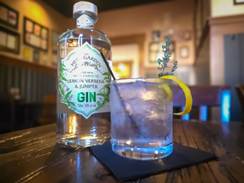 A bottle of gin and a glass of ice on a table

AI-generated content may be incorrect.