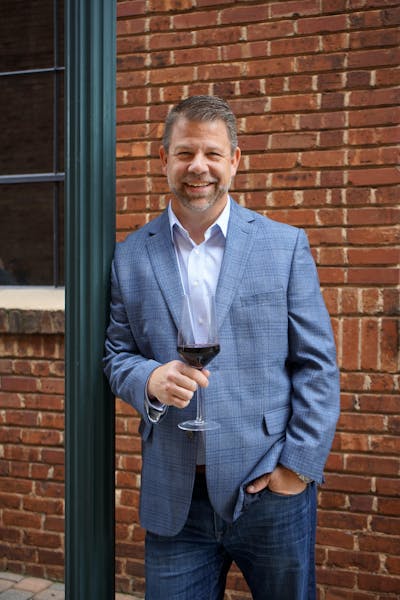 a man standing in front of a brick building