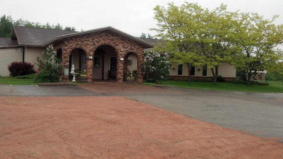a large brick building with grass in front of a house