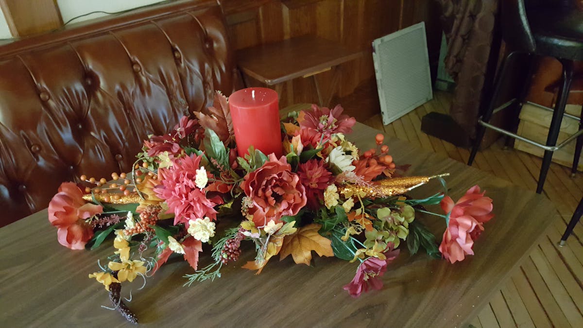 a vase of flowers sitting on top of a wooden table