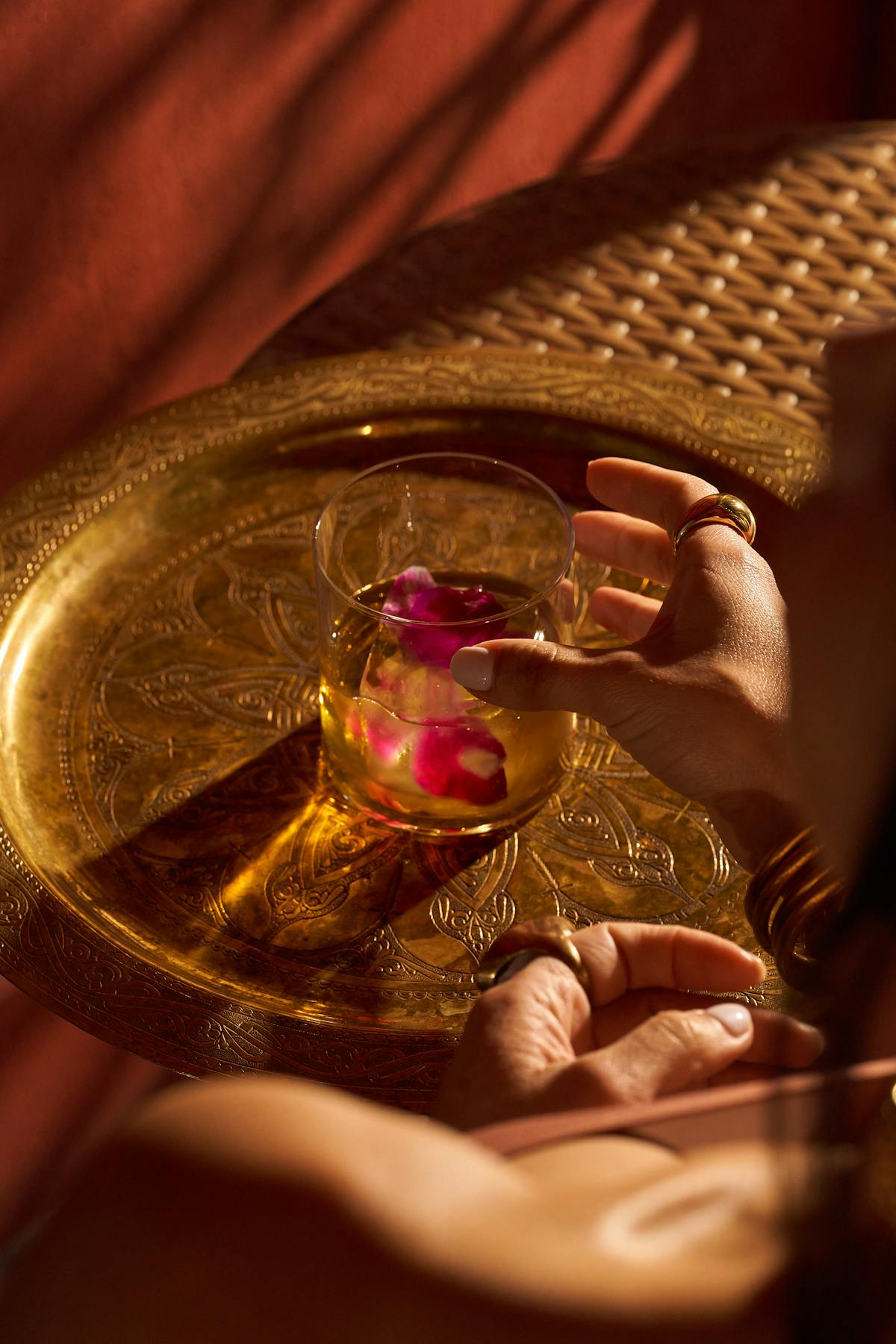 a hand holding a glass of beer on a table