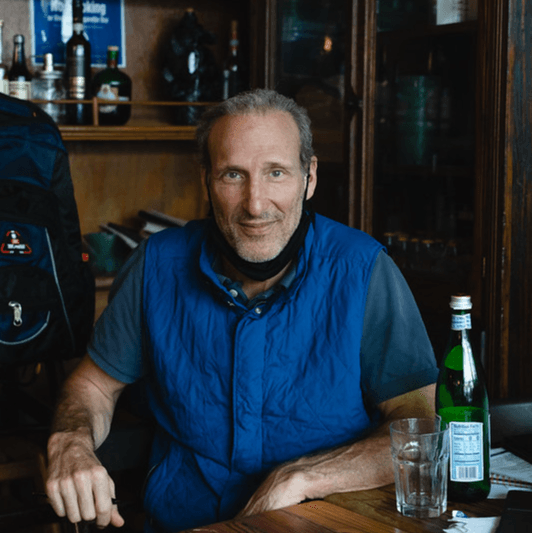 the owner in a blue shirt sitting at a table