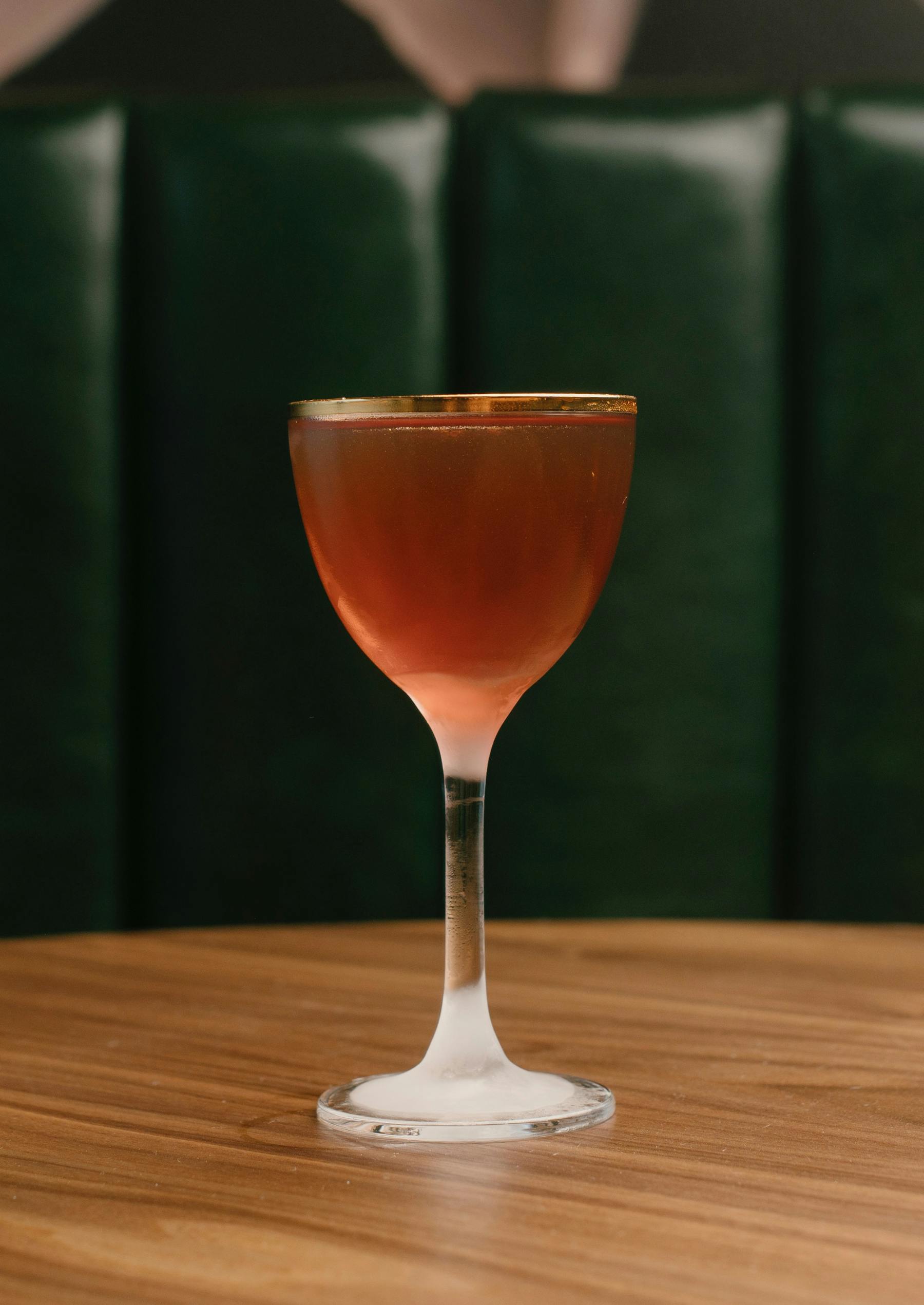 a glass of wine sitting on top of a wooden table