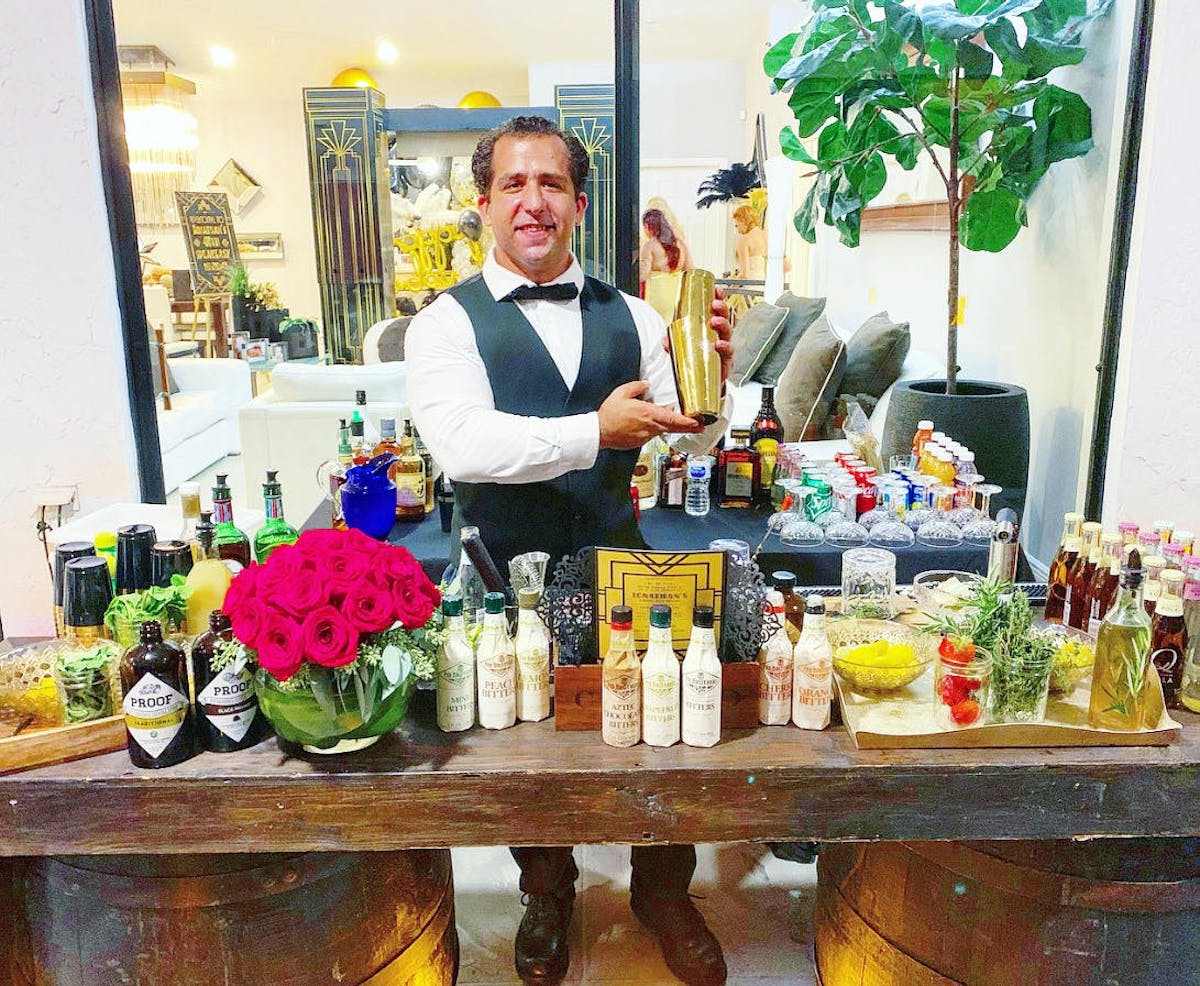 a person standing next to a vase of flowers on a table