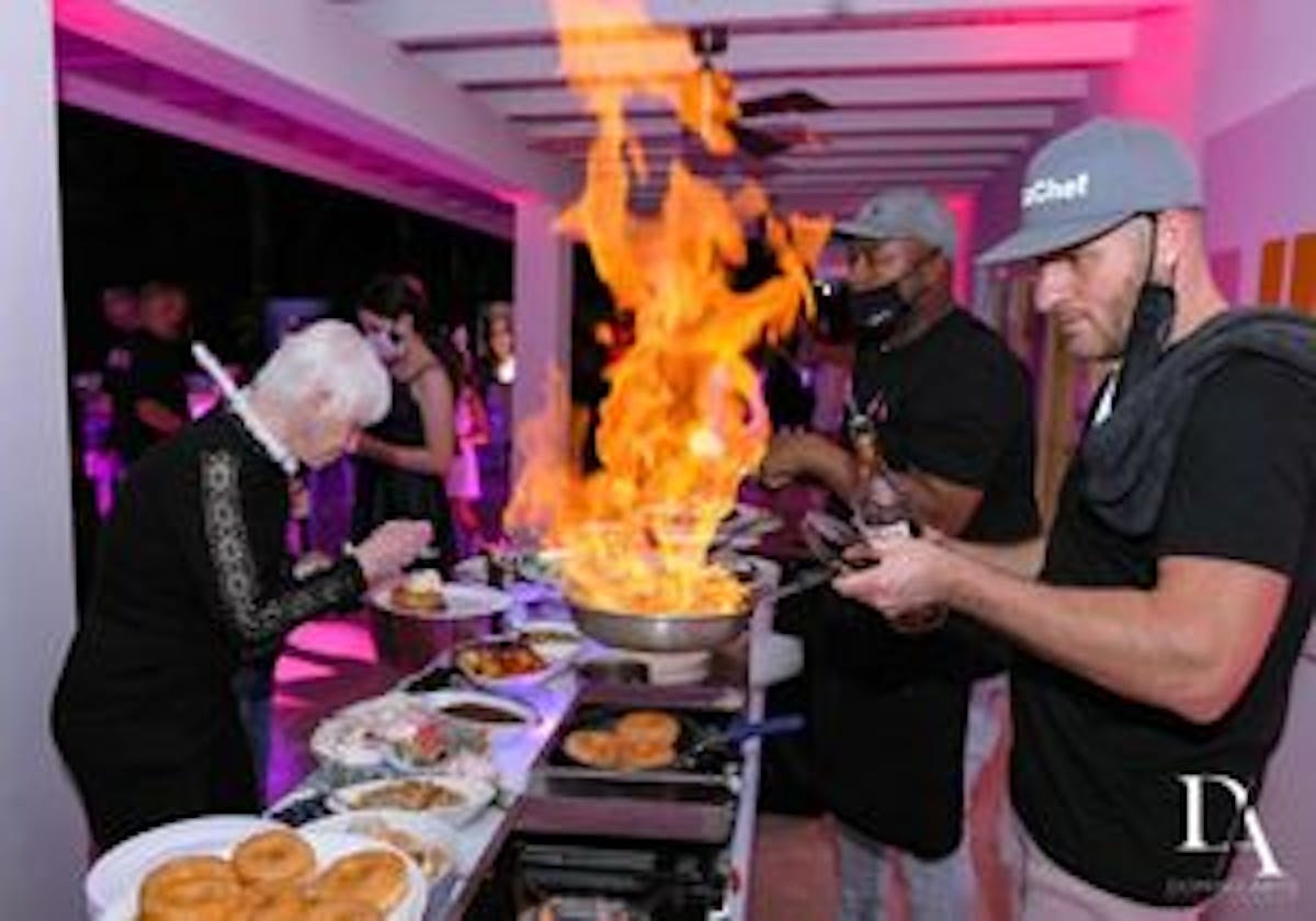 a group of people standing around a table, event planning service