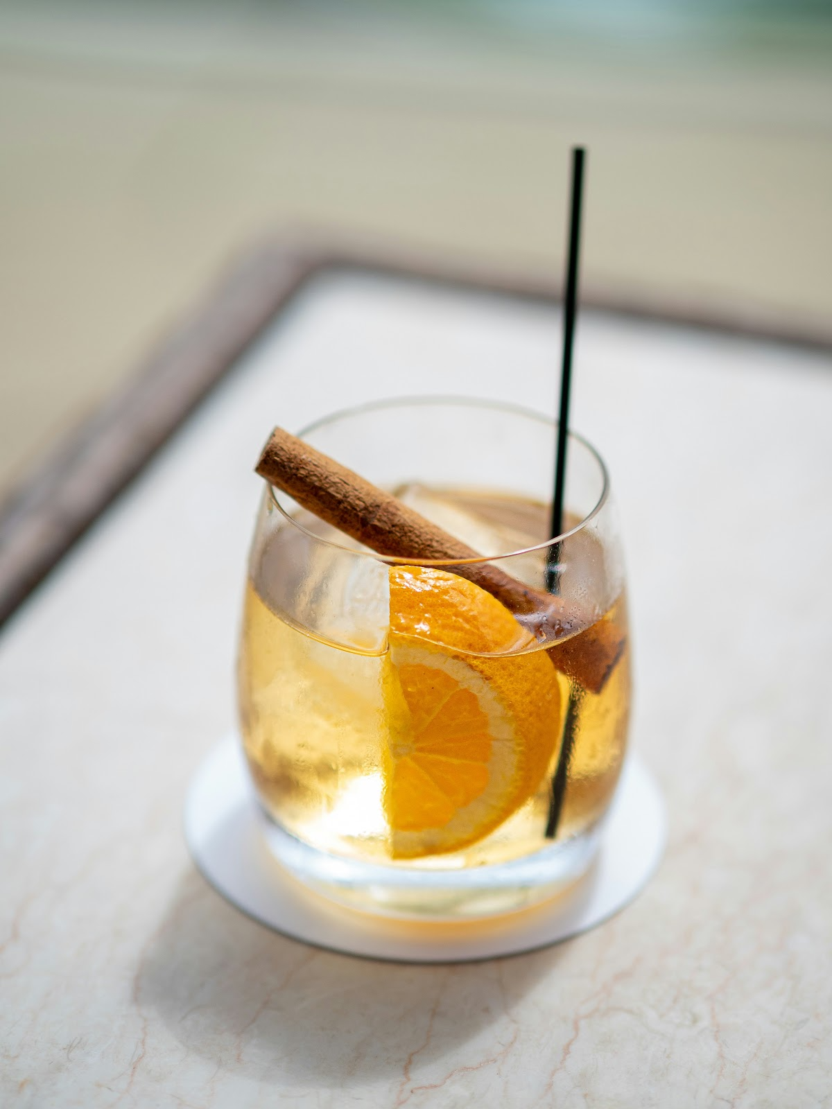 An elegantly garnished fall rum cocktail with a cinnamon stick and apple slice