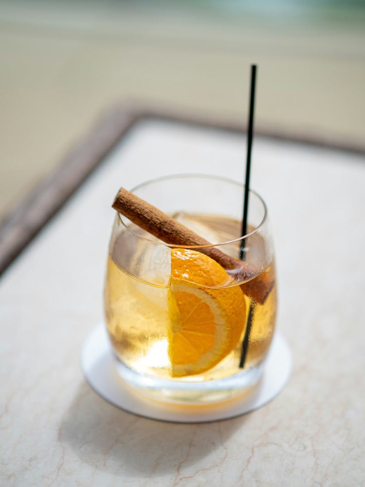 An elegantly garnished fall rum cocktail with a cinnamon stick and apple slice