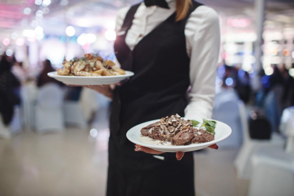 a person sitting at a table with a plate of food, event planning service
