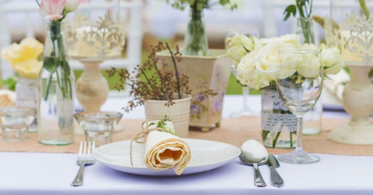 Elegant bespoke catering table setup with flowers, candles, and fine dining arrangement