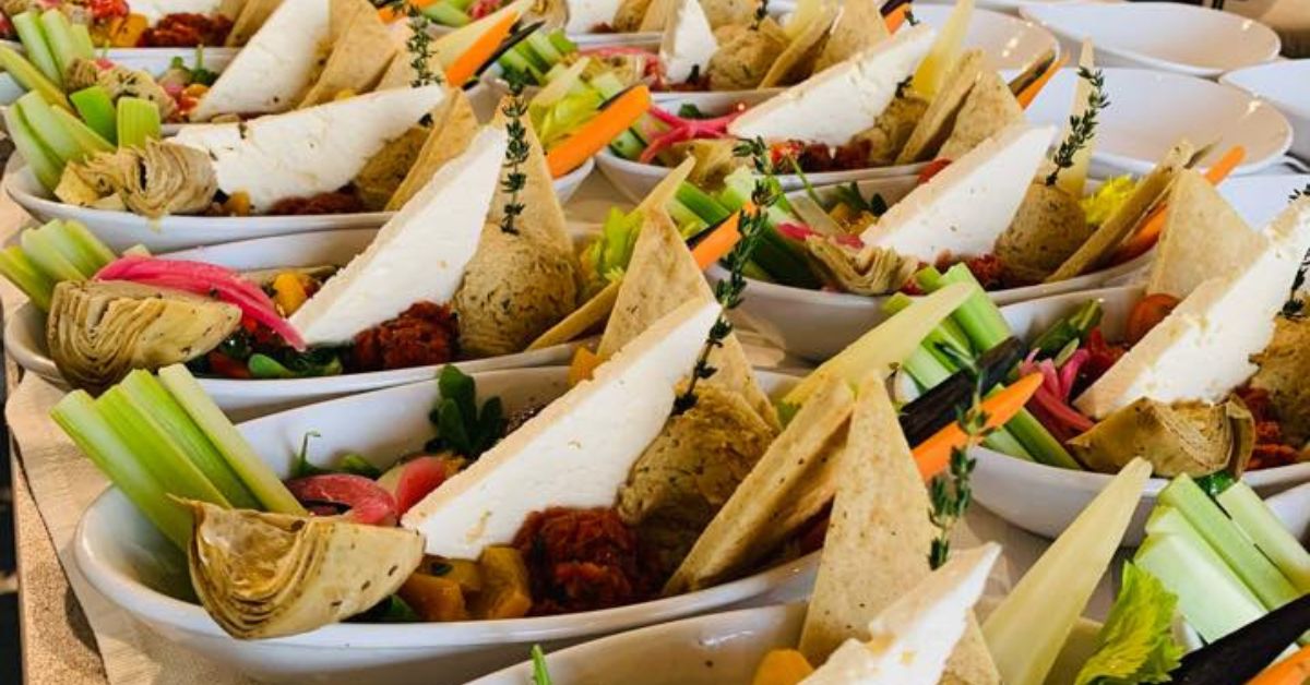 Fresh vegan vegetable bowls with dips, herbs, and crackers for Boca Raton events