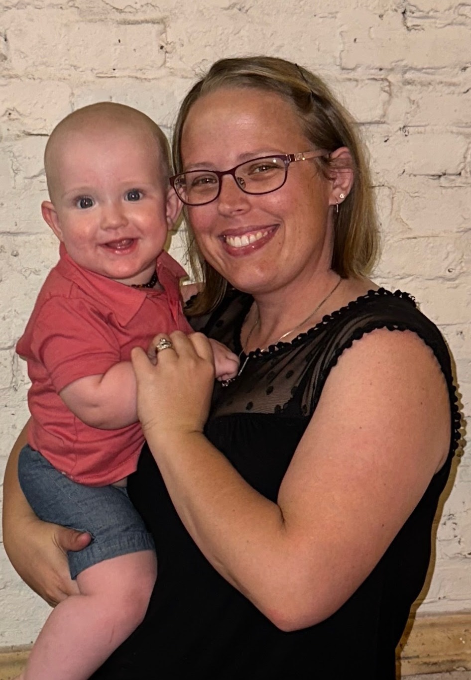 a woman holding a baby posing for the camera