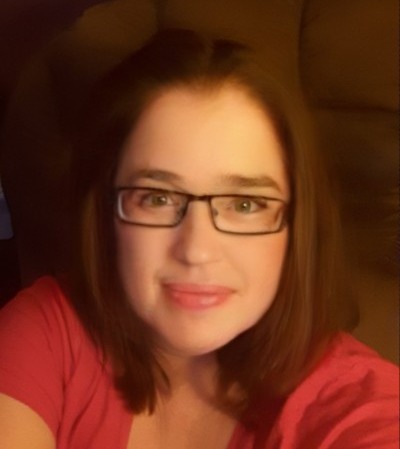 a woman in glasses looking at the camera