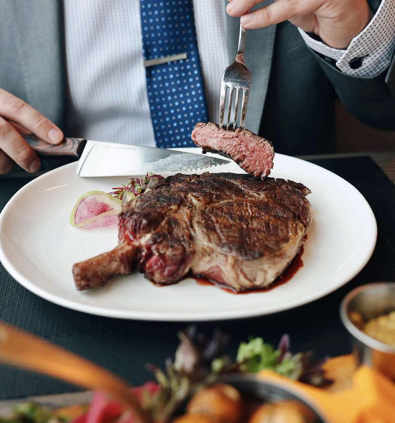 a woman sitting at a table with a plate of food