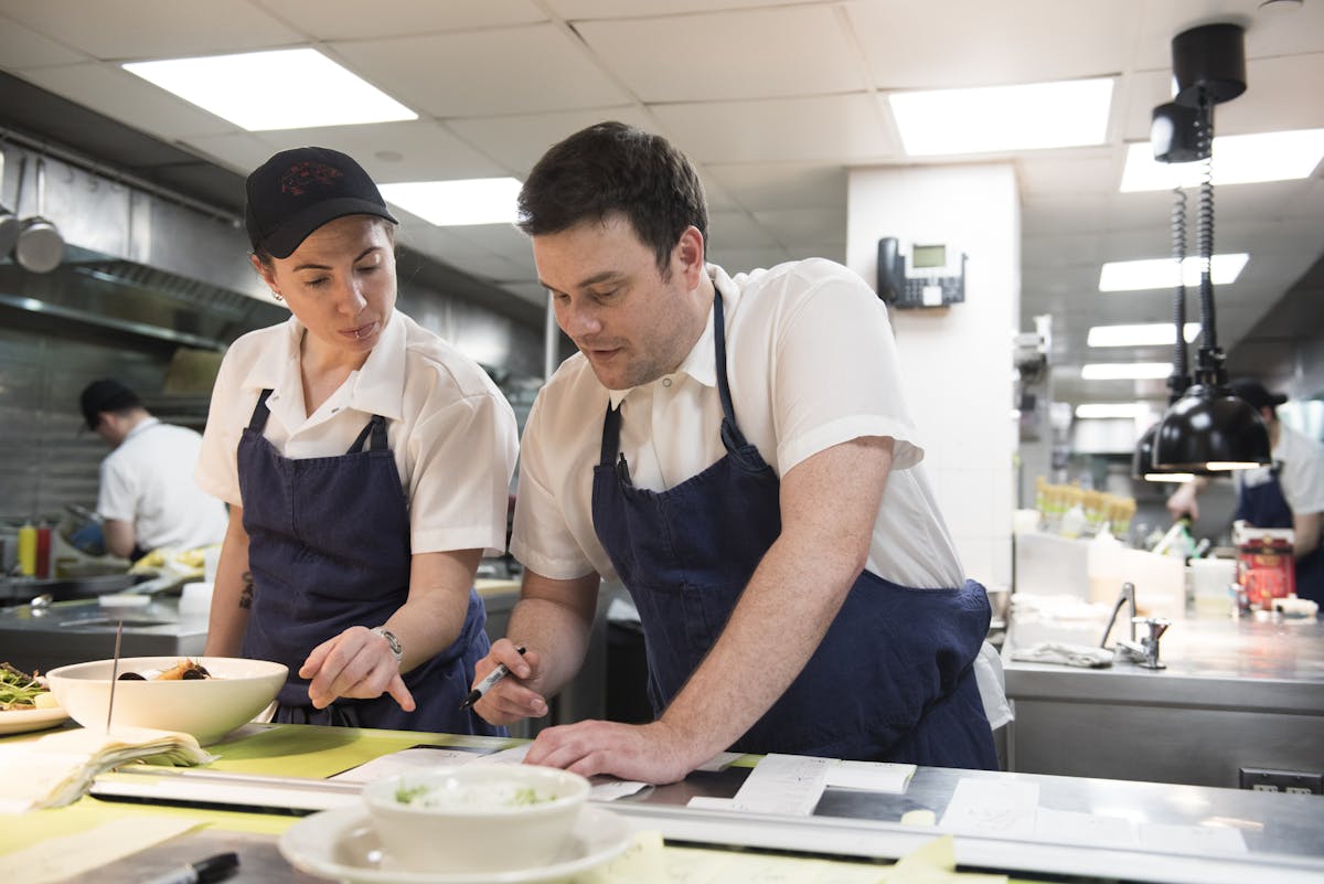 Chef de Cuisine Matt Spivey mentoring a colleague in the kitchen