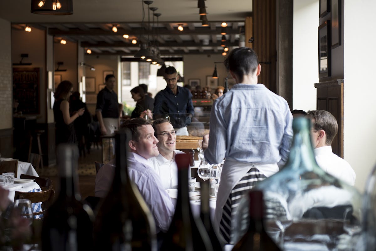 A server at Maialino interacting with guests