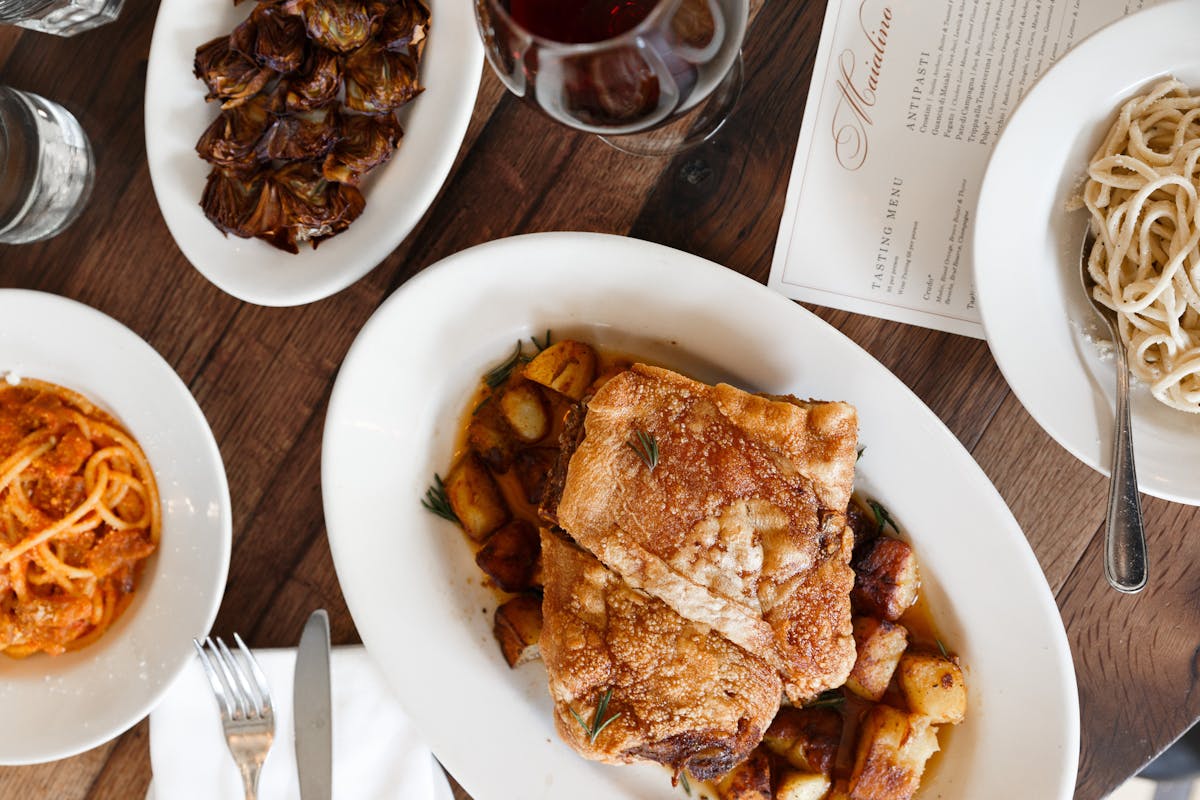 a spread of food at Maialino - roasted pork, pastas, and roman-style artichokes