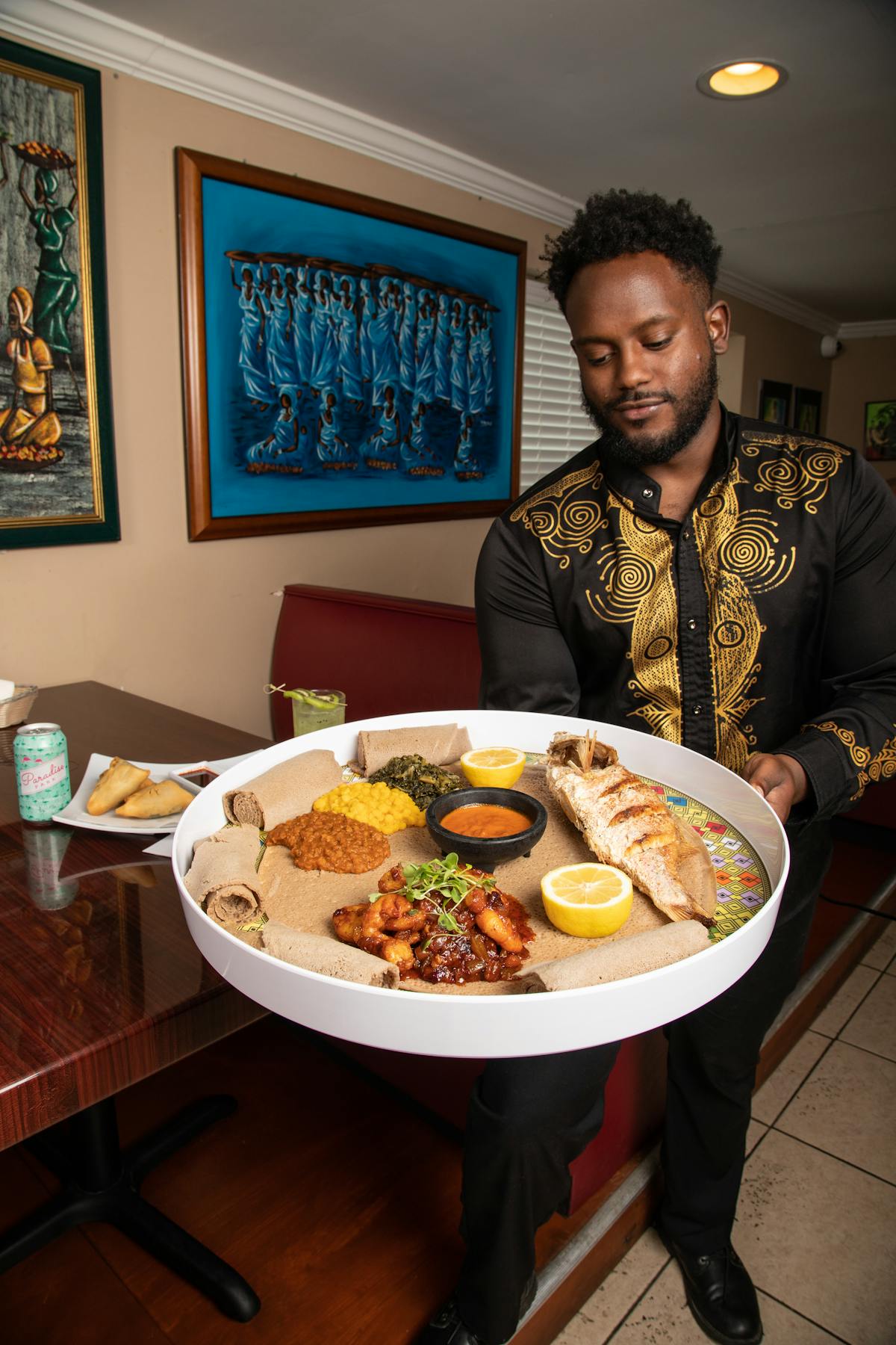 a man holding a plate of food on a table