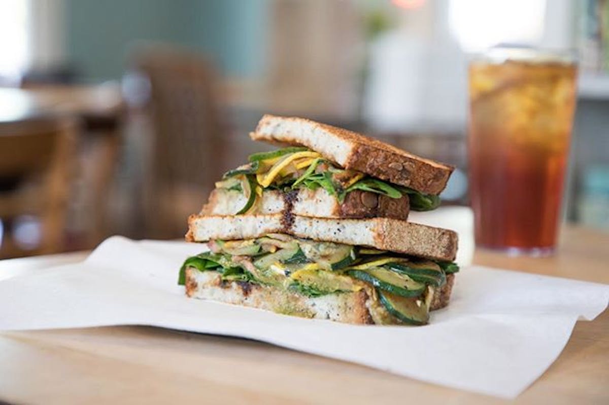 a cut in half sandwich sitting on top of a wooden table