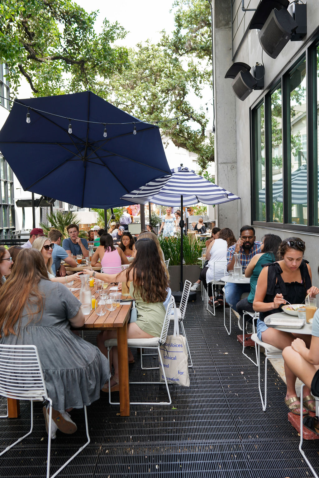 a group of people sitting at a table with an umbrella