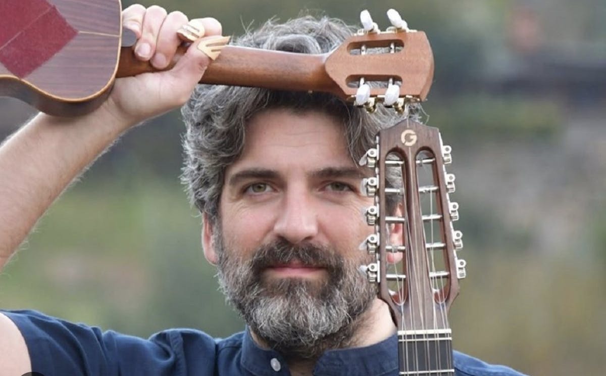 a close up of a man holding a guitar