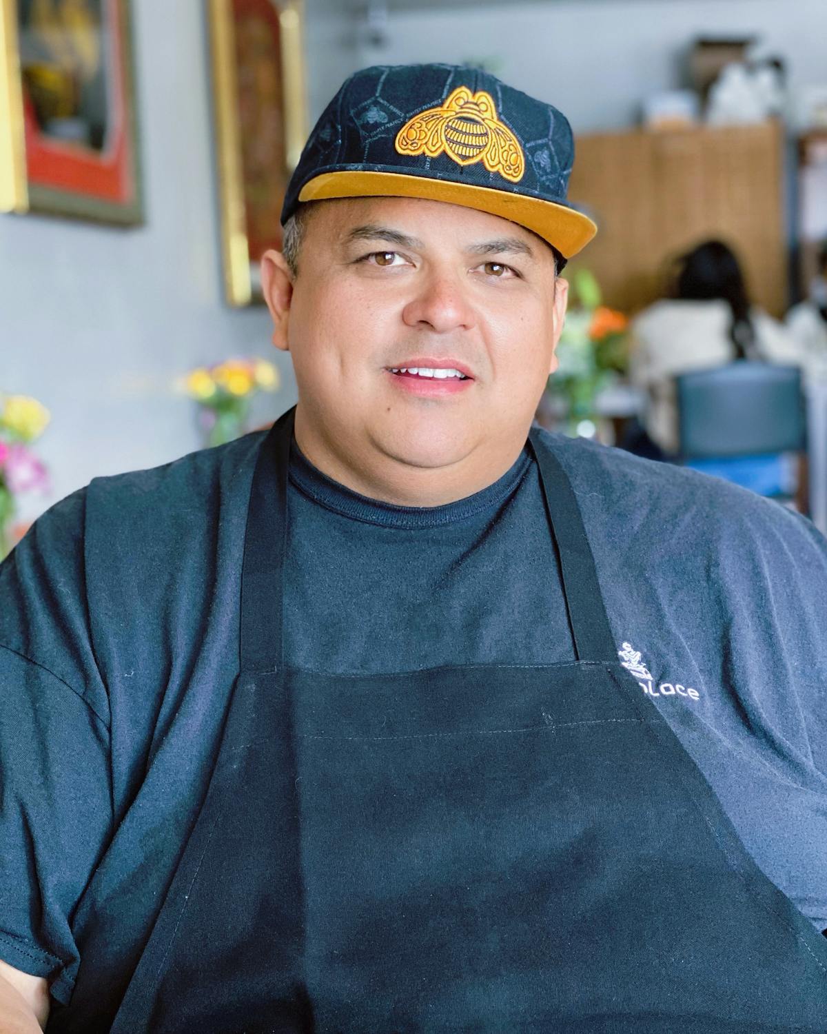 Chef smiling wearing an apron and ballcap