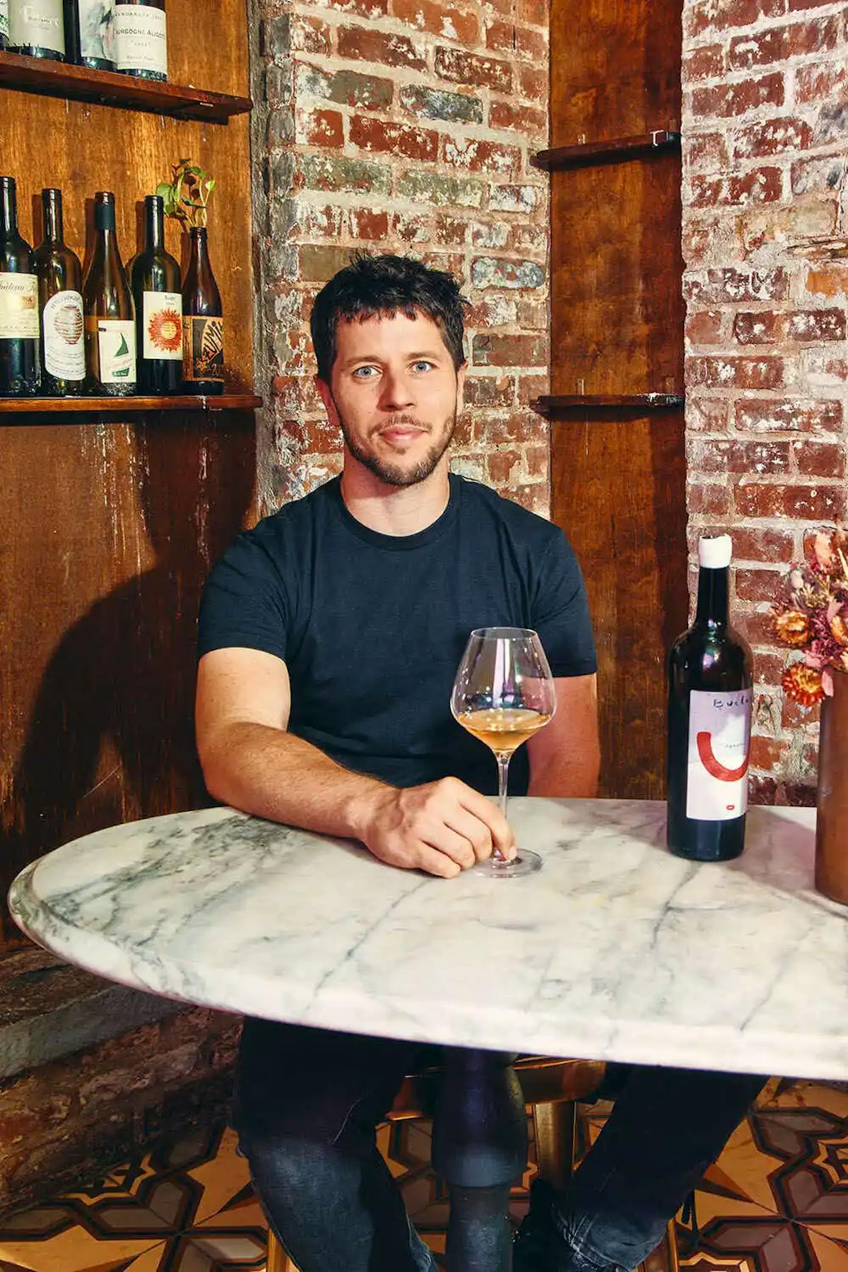 a man sitting at a table drinking wine