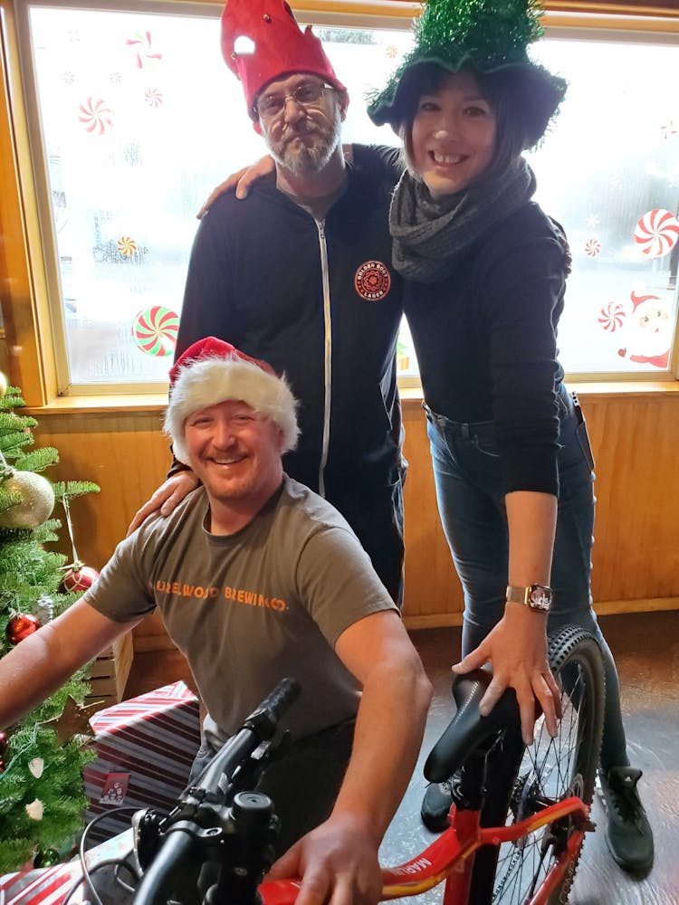 a man and a woman riding on the back of a bicycle