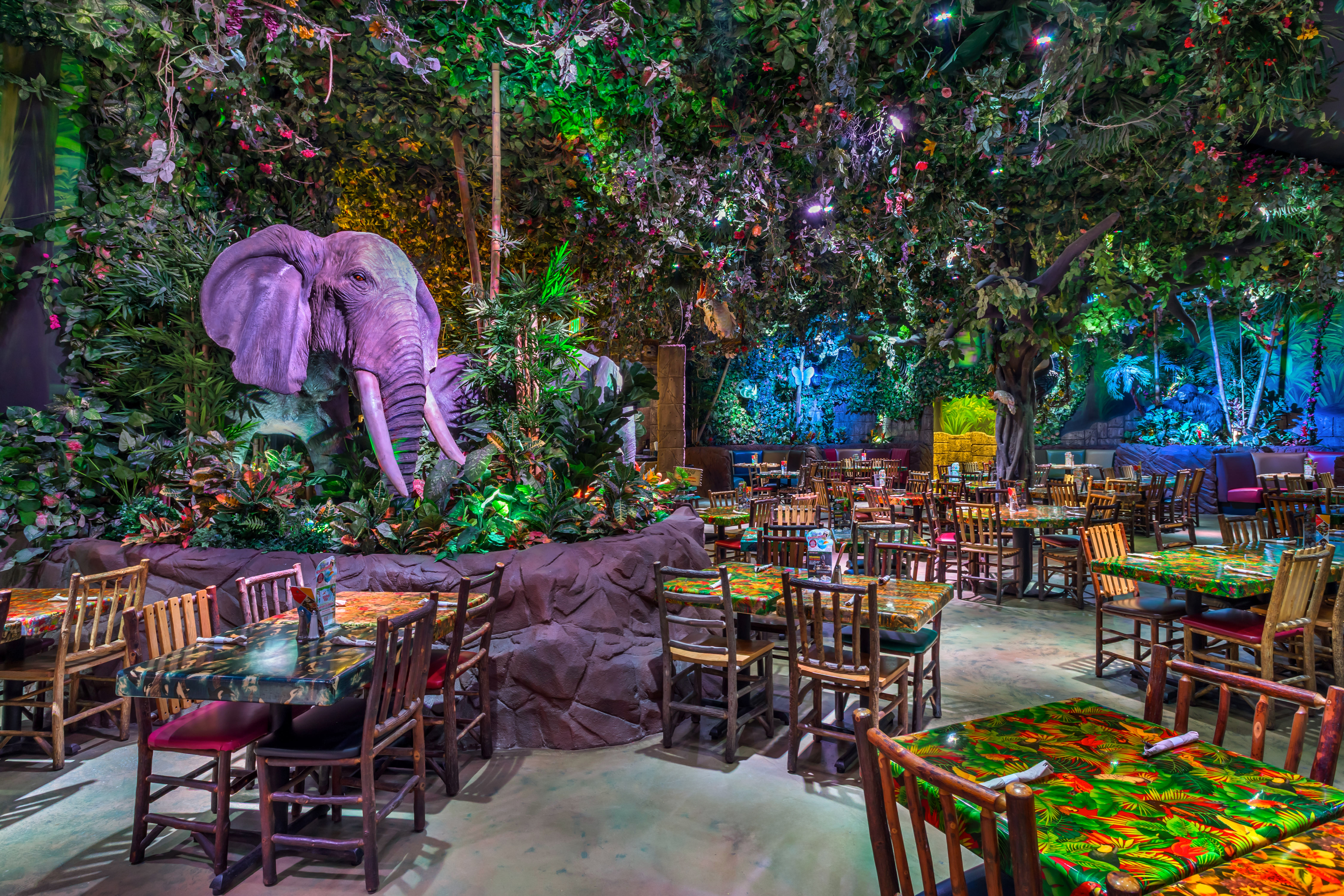Rainforest Cafe dining room surrounded by jungle foliage and animatronic animals