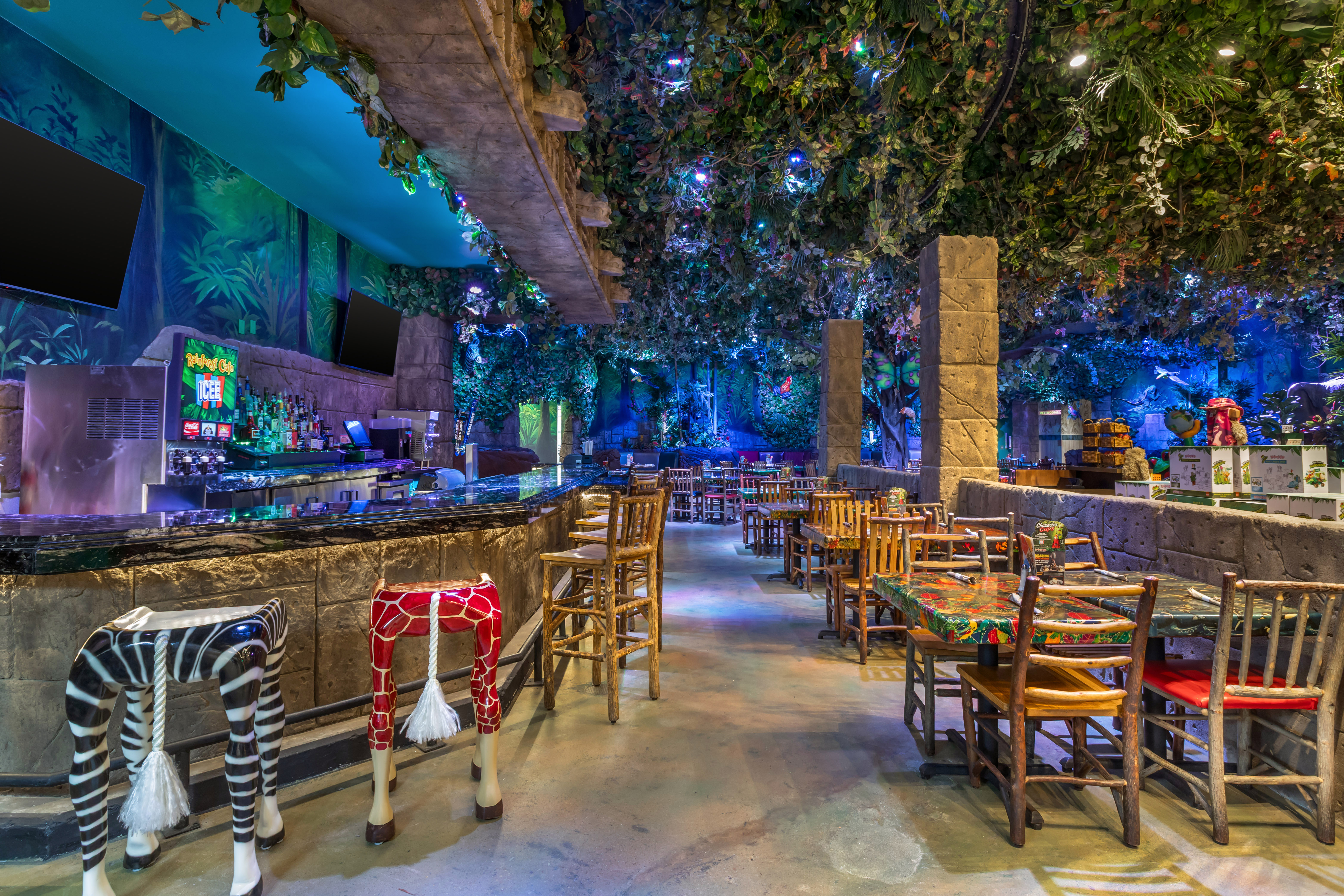 Tropical scenery and themed decor inside a Rainforest Cafe restaurant