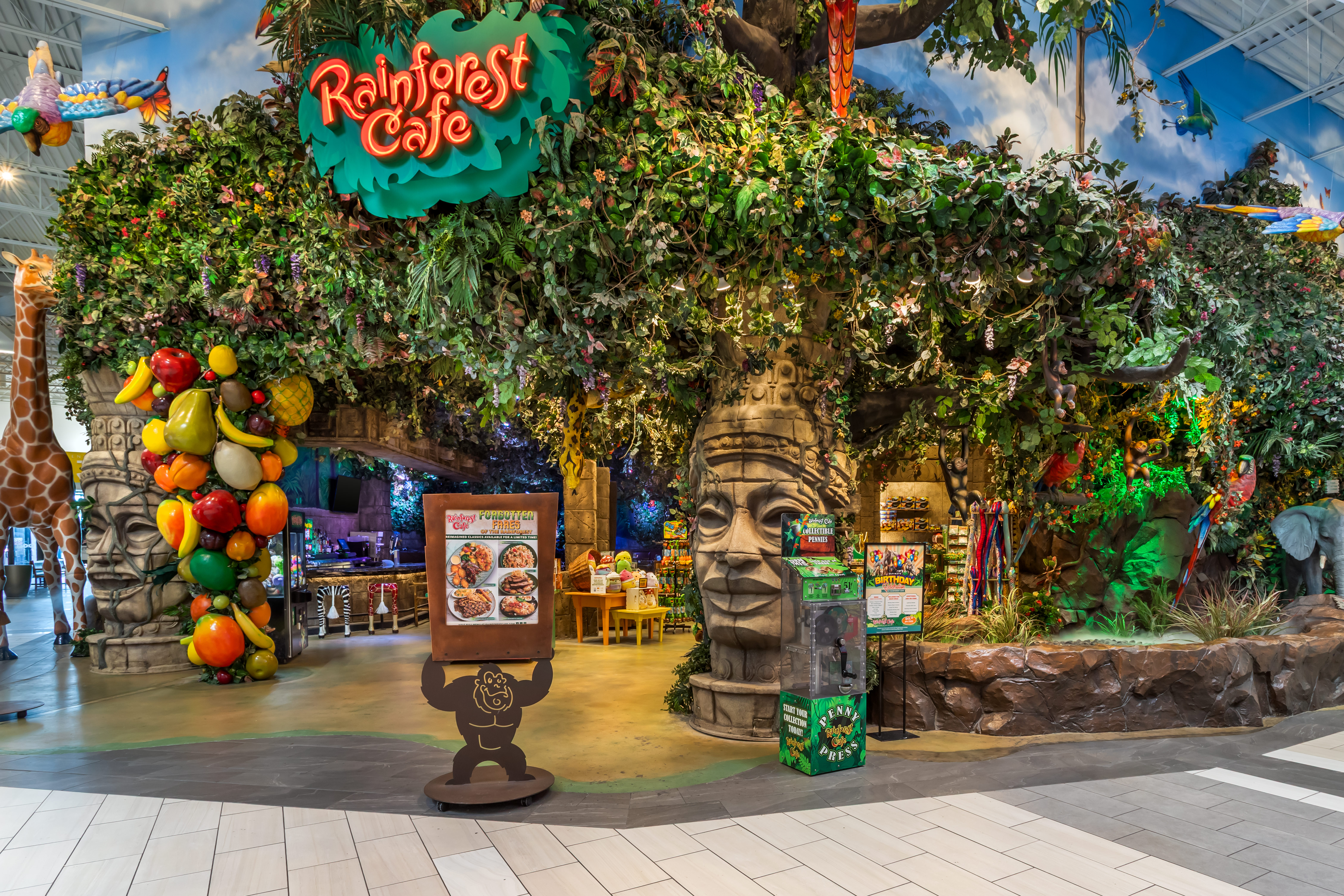 Jungle-themed dining area at Rainforest Cafe with lush greenery and animatronic animals