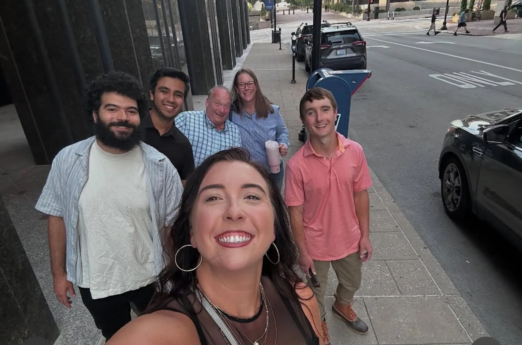 a group of people standing on a sidewalk
