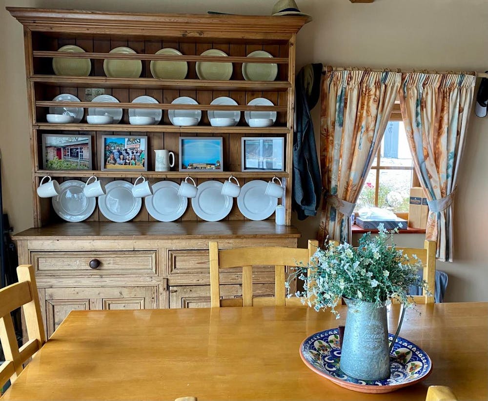 a room filled with furniture and vase of flowers on a wooden table