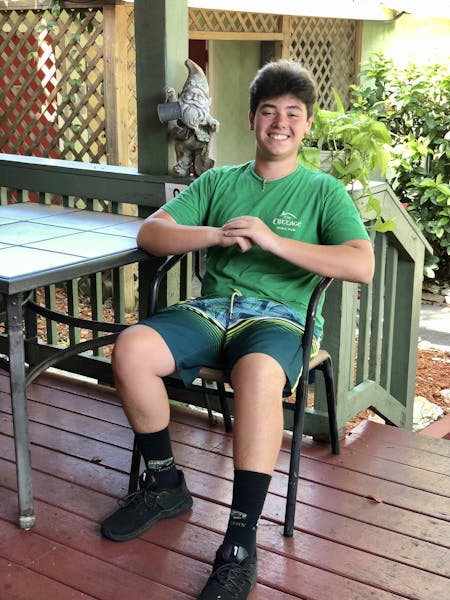 a person in a green park bench sitting on top of a wooden fence
