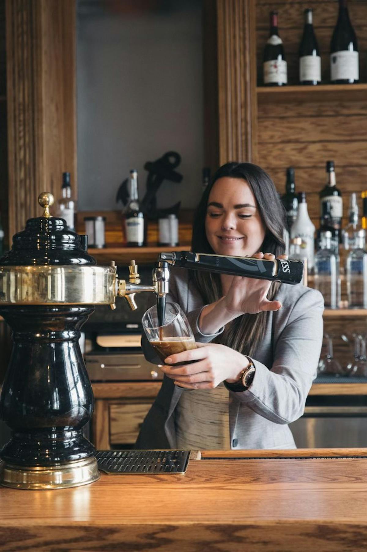 a person holding a glass of beer on a table