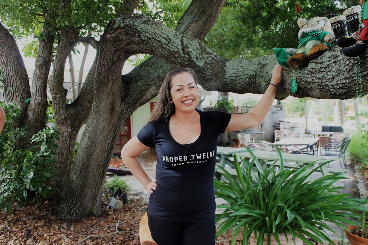 a woman standing in front of a tree