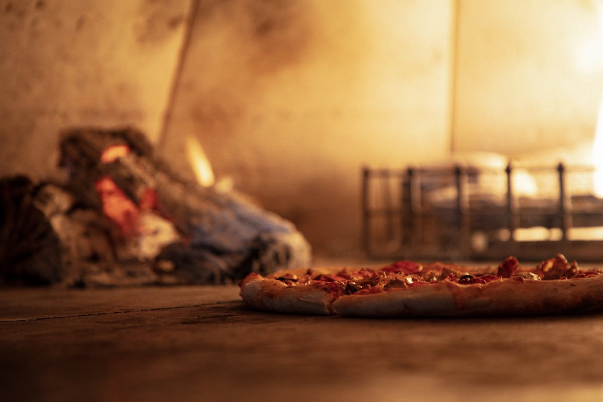 a pizza baking inside a brick oven
